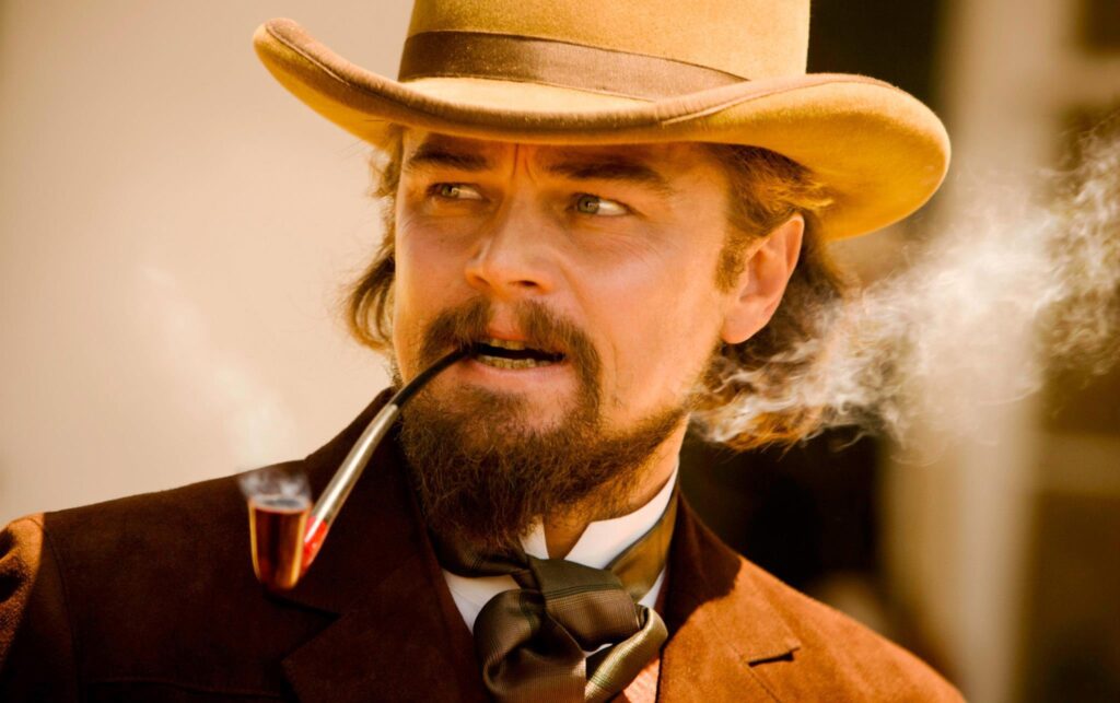 Close up of Leonardo DiCaprio Smoking a Pipe in a brown suit with a beige cowboy hat
